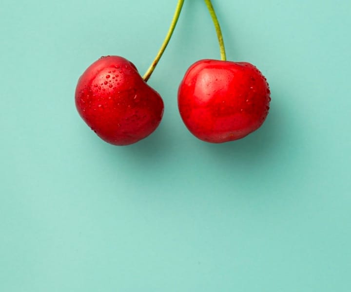 2 wet cherries on a calm green background