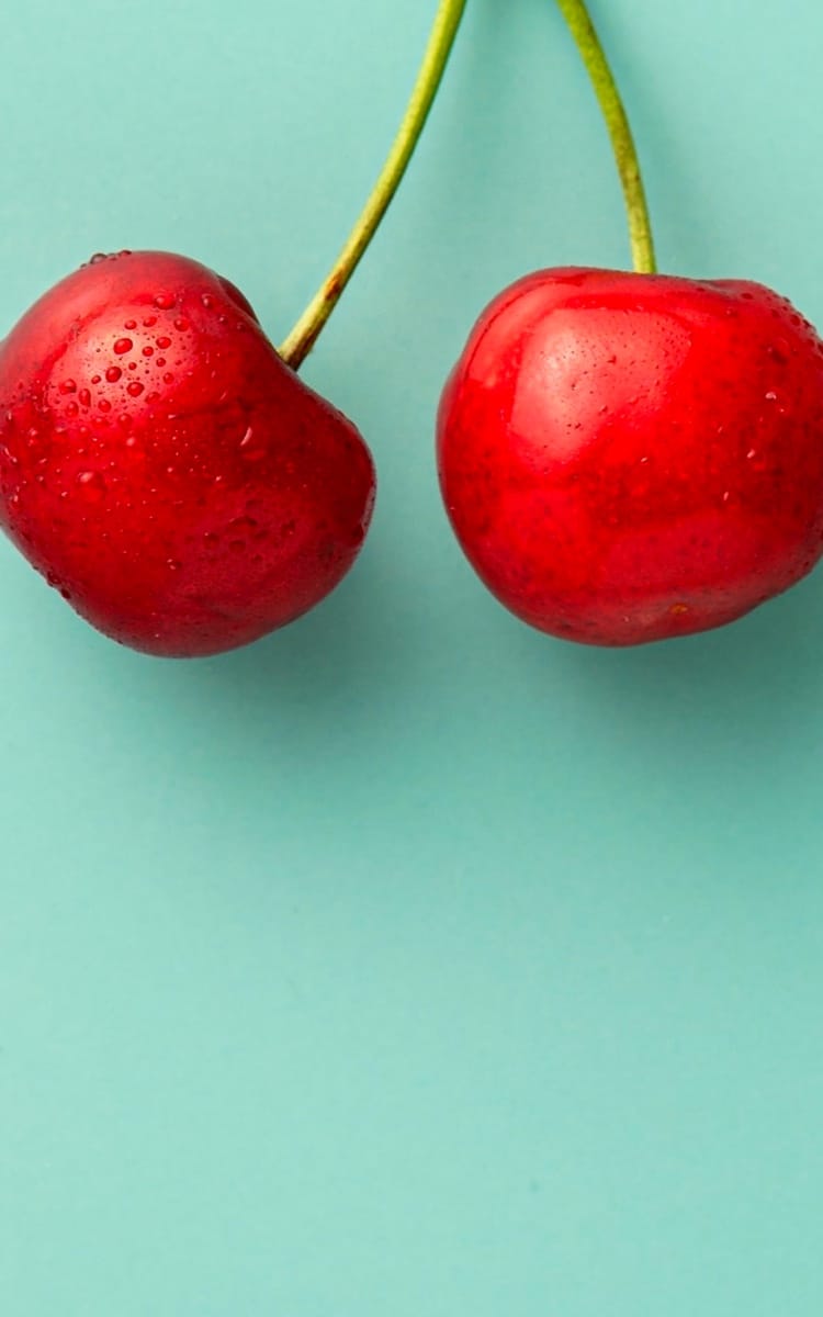 2 wet cherries on a calm green background